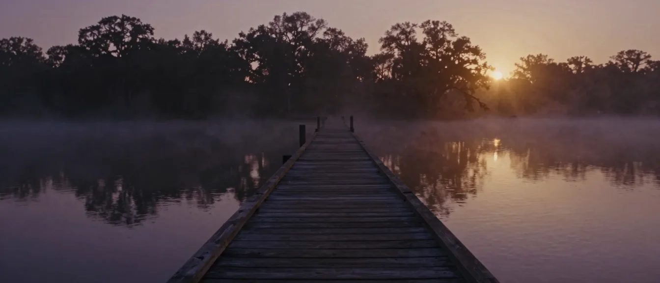 A wooden sound-side pier receding into low mist at dawn
