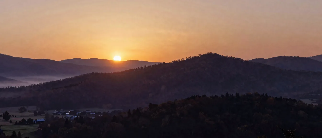 Farms scattered across a mountain valley at dawn