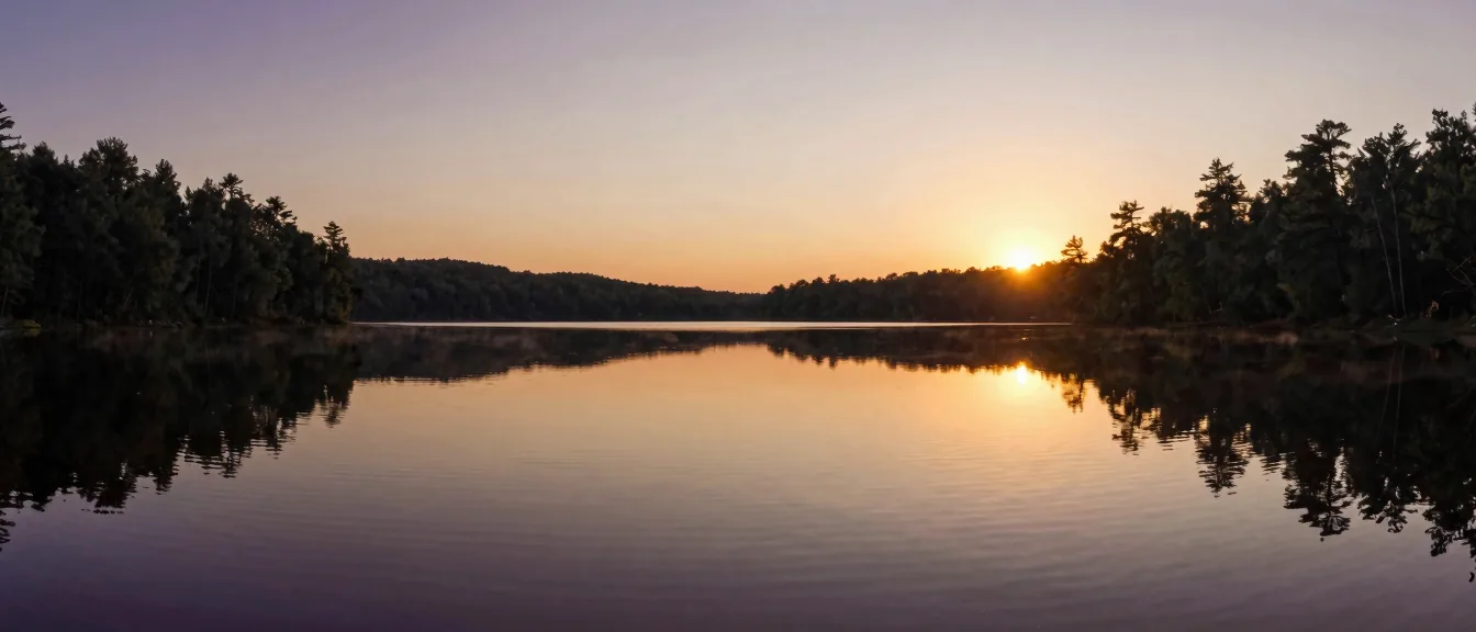 A lake lying mirror-flat at golden hour